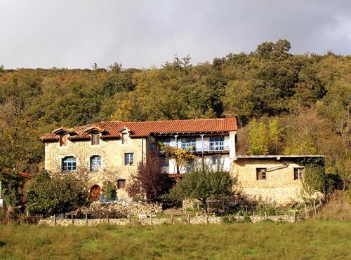 a large stone house in the middle of a field at Casa BlaBlao 