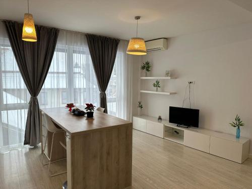 ein Wohnzimmer mit einem Tisch und einem TV in der Unterkunft Anastasia Apartment in Timişoara
