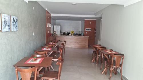 a restaurant with wooden tables and chairs and a counter at Pousada Tia Alice in Penha