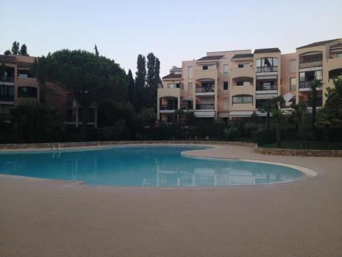 une piscine vide en face de certains immeubles d'appartements dans l'établissement Tournamy Les Olivier, à Mougins