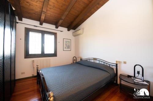 a bedroom with a bed in a room with a window at Villa Cycas in Polpenazze del Garda