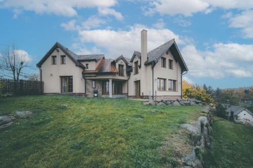 a house on top of a grassy hill at Chalupa Lodge in Varvažov