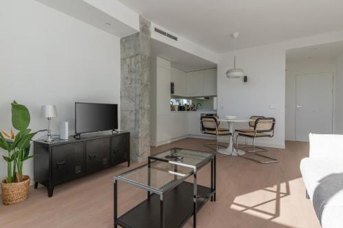 a living room with a couch and a table with chairs at Bright with views -2Bd 1Bth- Bernabeu in Madrid