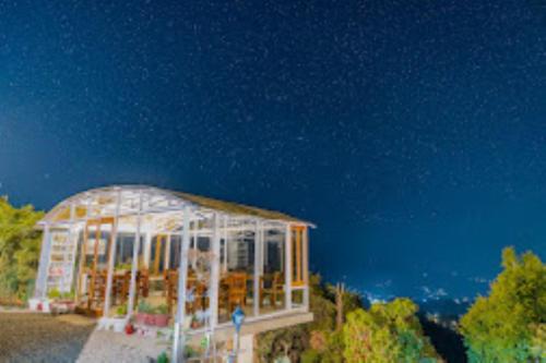 a greenhouse in the middle of a field at night at SHIVAYA since 1953 , Mukteshwar in Mukteshwar