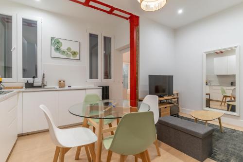 eine Küche und ein Esszimmer mit einem Glastisch und Stühlen in der Unterkunft Cozy and Central-1Bd 1Bth- Cortes in Madrid
