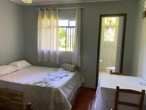 a bedroom with two beds and a window at Pousada do colono in Morretes
