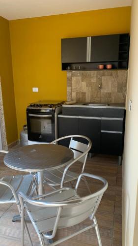 a kitchen with a table and two chairs and an oven at Casa flet em serrambi praia in Porto De Galinhas