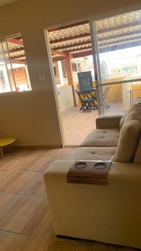 a living room with a couch and a view of a patio at Casa flet em serrambi praia in Porto De Galinhas