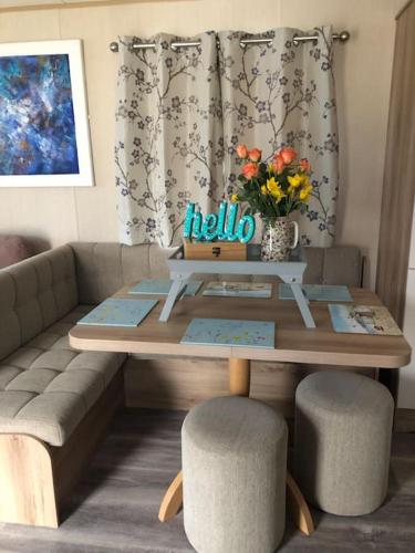 a coffee table with a couch and a table with flowers at Pinto Holiday Home Oakdene Forest Park Passes Inc! in Ringwood