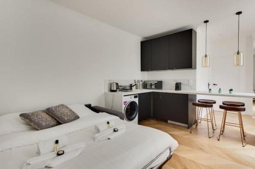 Cette chambre blanche dispose d'un lit et d'une cuisine. dans l'établissement Appartement Moderne au coeur du 7ème, à Paris