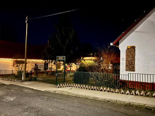 Ein Zaun am Straßenrand nachts in der Unterkunft Alma Hof Vendégház in Boldogasszonyfa