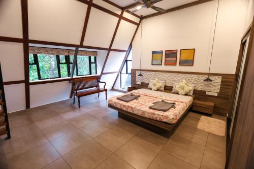 Habitación grande con cama y silla en The Preserve Stone House Bungalow, en Meppādi