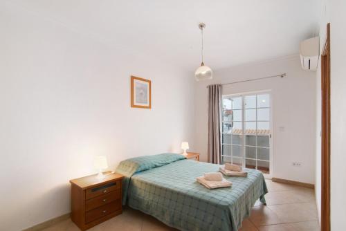 a bedroom with a bed and a dresser and a window at Moradia Altura in Altura