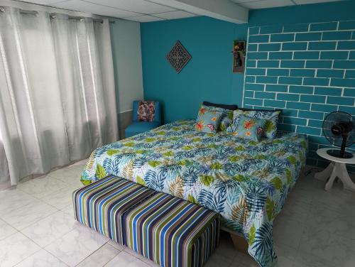 1 dormitorio con cama y pared azul en La Bella Vista en Calarcá