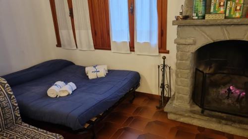 1 dormitorio con cama azul y chimenea en Villetta con ampio giardino, en Montepiano