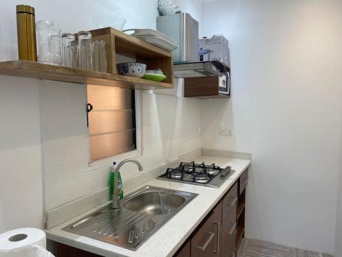 uma cozinha com um lavatório e um fogão em EL HOGAR em Accra