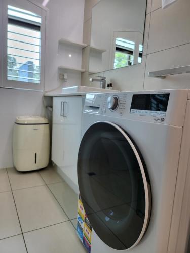 a white washing machine sitting in a kitchen at Byron Bay Beachfront Apartments in Byron Bay