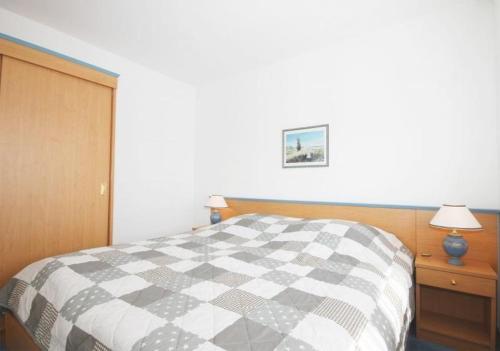 1 dormitorio con cama a cuadros en blanco y negro en Strandschloesschen-Haus-I-WE-5-strandnah-9971, en Kühlungsborn