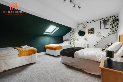 Spacious 5-Bedroom Oasis with Games Room-Liverpool في ليفربول: غرفة نوم بسريرين وجدار أخضر