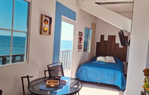 a bedroom with a bed and a table and a window at Warm sunset, Loft by the sea in La Libertad