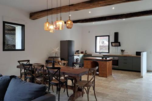 une cuisine et une salle à manger avec une table et des chaises dans l'établissement Grange 10 personnes, à Billère