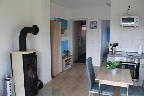 - une cuisine avec une table et une cheminée dans la chambre dans l'établissement Fewo Möwe Lütow Usedom Achterwasser blaues Haus, à Lütow