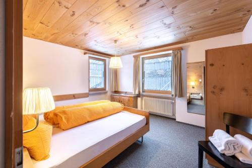 a bedroom with a bed in a room with wooden ceilings at Chasa Val 2 in Scuol