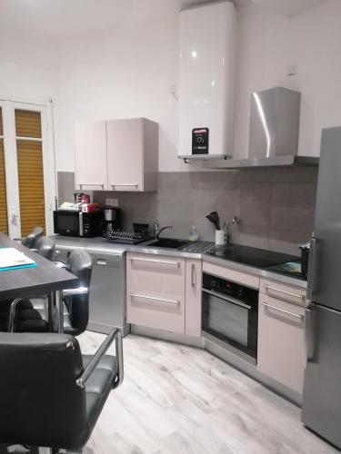 uma cozinha com electrodomésticos brancos e uma mesa com cadeiras em Dolce vita em Nice