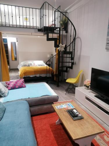 Dolce vita في نيس: غرفة معيشة مع أريكة ودرج حلزوني