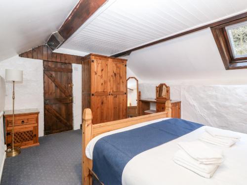 um quarto com uma cama de madeira e um lavatório em Is Y Graig em Caernarfon