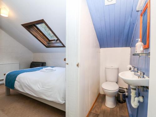y baño con cama, lavabo y aseo. en Is Y Graig en Caernarfon