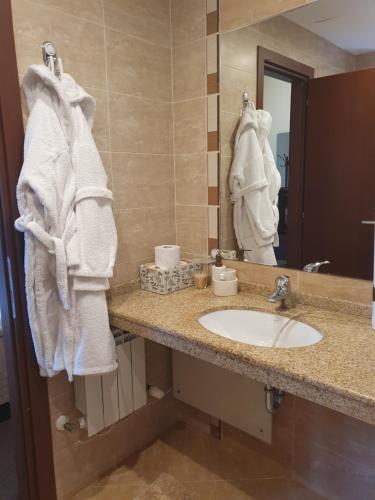 a bathroom with a sink and a mirror and towels at Apartment ZAX B7 in Terra Complex in Bansko