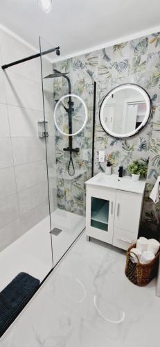 łazienka z prysznicem, umywalką i lustrem w obiekcie Apartamento “La Guapa” Benidorm! w mieście Benidorm