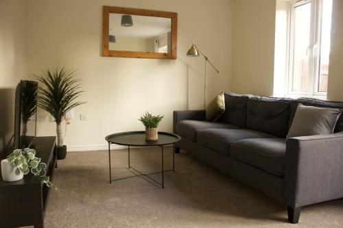 un soggiorno con divano e tavolo di Spacious 4 bedroom, perfect for contractors, families, private parking a Wootton Bassett