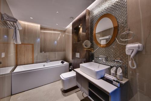 y baño con bañera, lavabo y aseo. en Quality Inn Elite, Amritsar en Amritsar