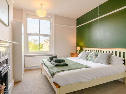 um quarto com uma cama grande e uma parede verde em 4 Bed in Hornsea 89887 em Hornsea
