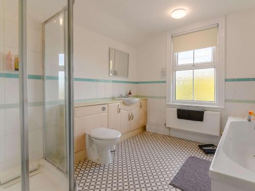 a bathroom with a toilet and a sink and a shower at 4 Bed in Hornsea 89887 in Hornsea