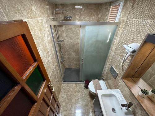 a small bathroom with a shower and a sink at Sultan Suite, Entrance Floor in Antalya