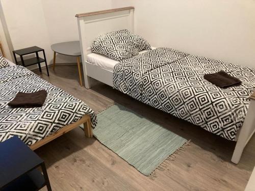 a room with two beds and a table and a table at City Center Superb inside 3 Bedroom+Living room Apartment in Szombathely