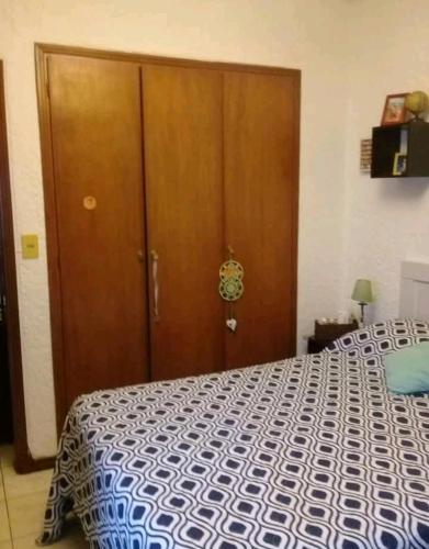 1 dormitorio con 1 cama y puerta de madera en Socipavi en Maldonado