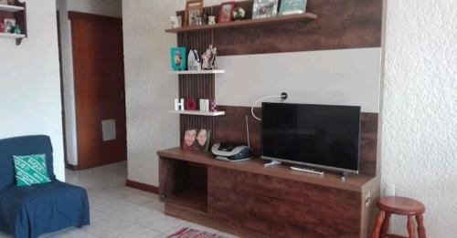 uma sala de estar com uma televisão numa secretária de madeira em Socipavi em Maldonado