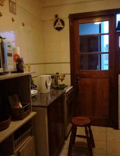 a kitchen with a wooden door and a stool at Socipavi in Maldonado