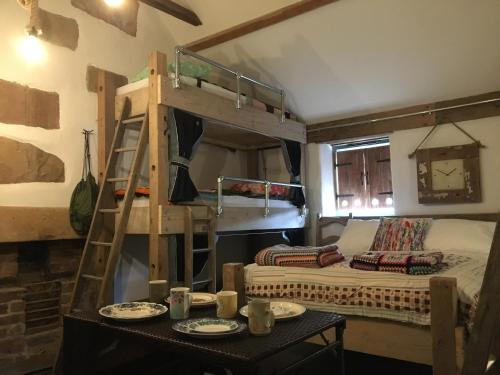 Cette chambre comprend des lits superposés et une table avec de la vaisselle. dans l'établissement Matlock Glamping Rooms, à Matlock