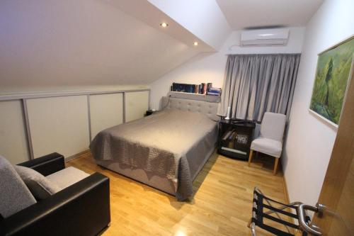 - une petite chambre avec un lit et une chaise dans l'établissement VILLA OTOK WITH POOL, TOP LUXURY IN TREBINJE, à Trebinje