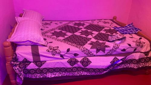 a purple bed with a quilt on it in a room at Coorg Green Moon in Madikeri