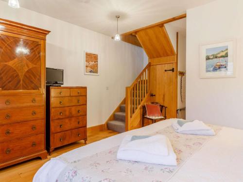 a bedroom with a bed and a dresser and a staircase at 1 Bed in Hope Cove 90026 in Hope Cove