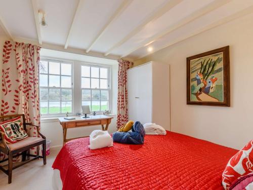 1 dormitorio con cama roja, escritorio y ventana en 4 Bed in AYR 90038 en Ayr