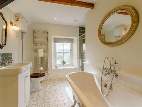a bathroom with a tub and a toilet and a mirror at 5 Bed in Crickhowell 90053 in Crickhowell