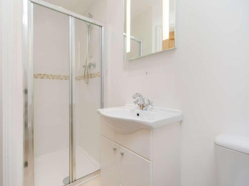a white bathroom with a sink and a shower at 1 Bed in Newquay 89942 in Mawgan Porth