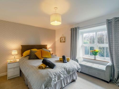 a bedroom with a bed with yellow pillows and a window at 1 Bed in Saltash 89873 in Pillaton